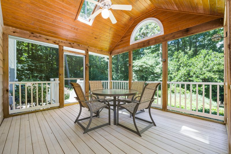 enclosed patio with lounge seats and a table and a roof fan