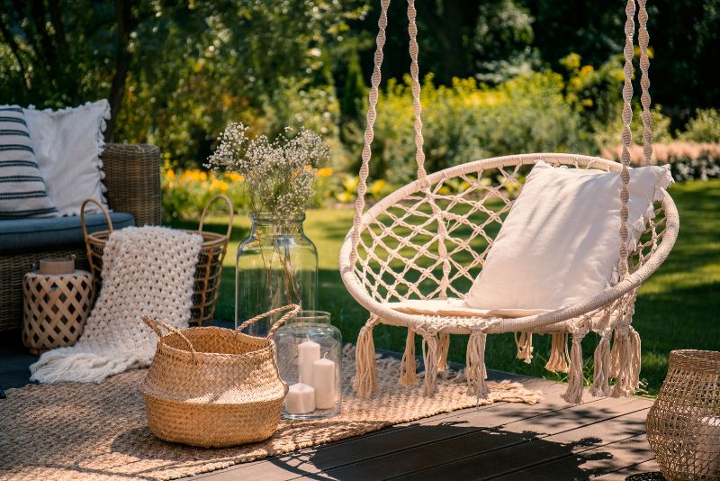 well decorated patio with candles, blankets, pillows and sitting area