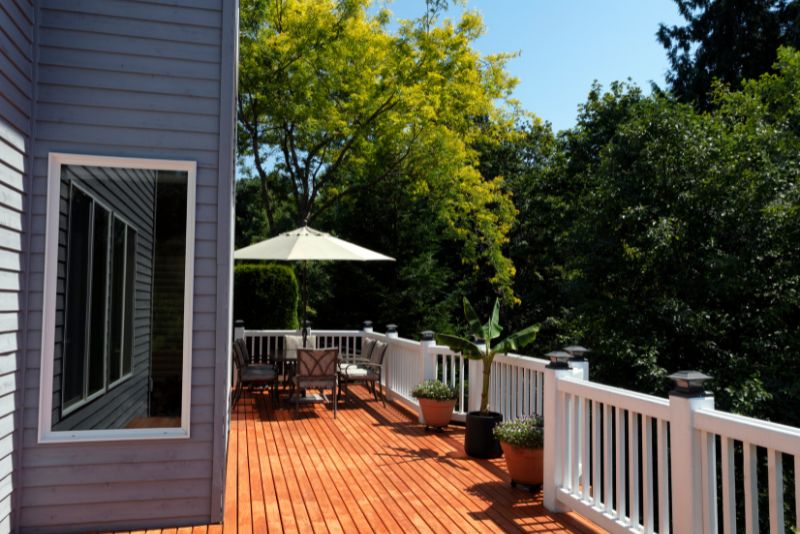 back deck with plants and a dining area