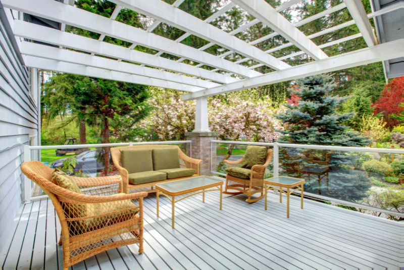 modern pergola painted white with a lounge area